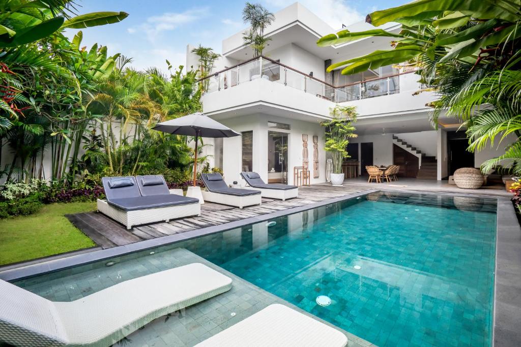 a villa with a swimming pool and a house at Villa GoodFellas by BaliSuperHost in Seminyak