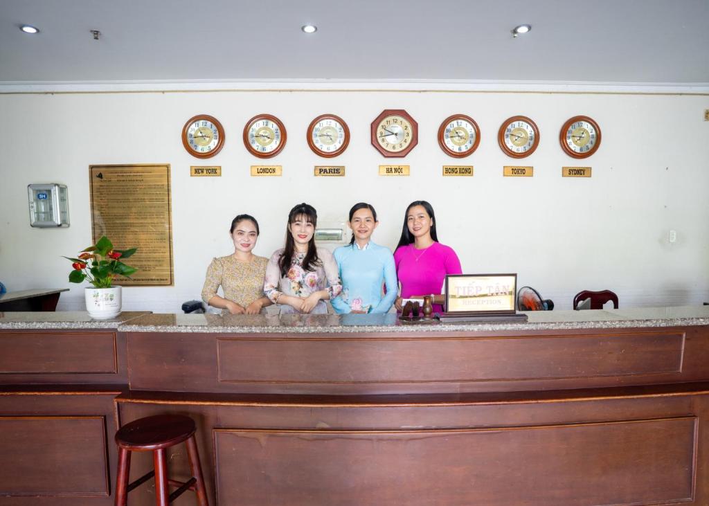 um grupo de quatro mulheres atrás de um balcão em Khách Sạn Bông Sen em Vị Thanh