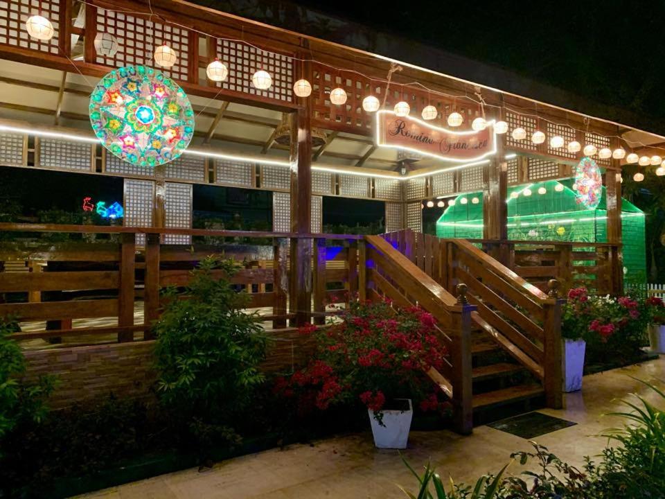un restaurante con una valla y flores y luces en RedDoorz Covelandia Garden Resort Nueva Ecija, 
