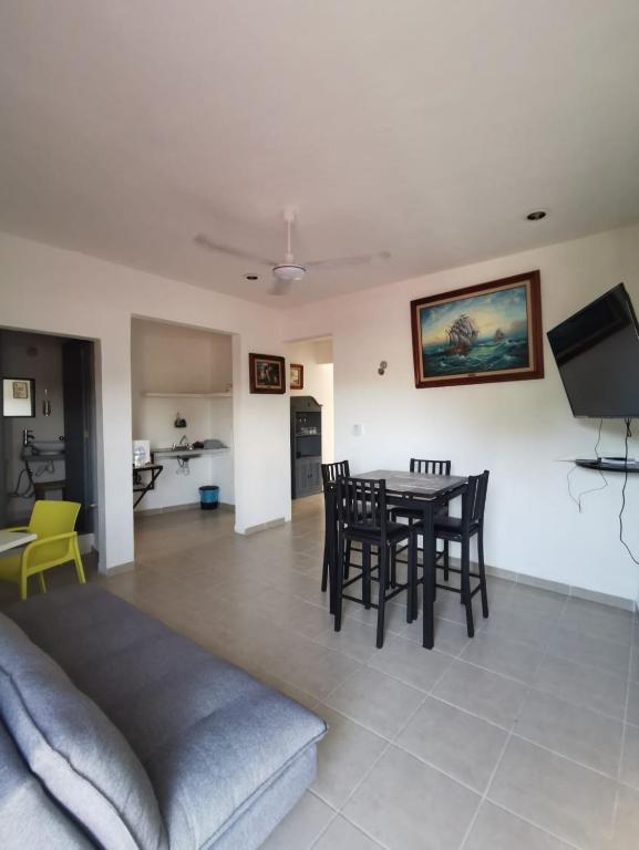 una sala de estar con una mesa y sillas en La casita del árbol, amplia y cómoda en barrio familiar, en Campeche