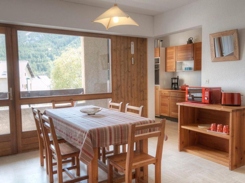 ル・モネティエ・レ・バンにあるAppartement Le Monêtier-les-Bains, 2 pièces, 7 personnes - FR-1-330F-32のキッチン、ダイニングルーム(テーブル、椅子付)