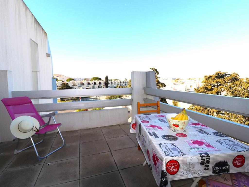 une table et une chaise sur un balcon dans l'établissement Appartement 2 Pièces Cabine avec Terrasse, Clim, Piscine et Proche Plage - 6 Couchages - FR-1-307-147, au Grau-du-Roi
