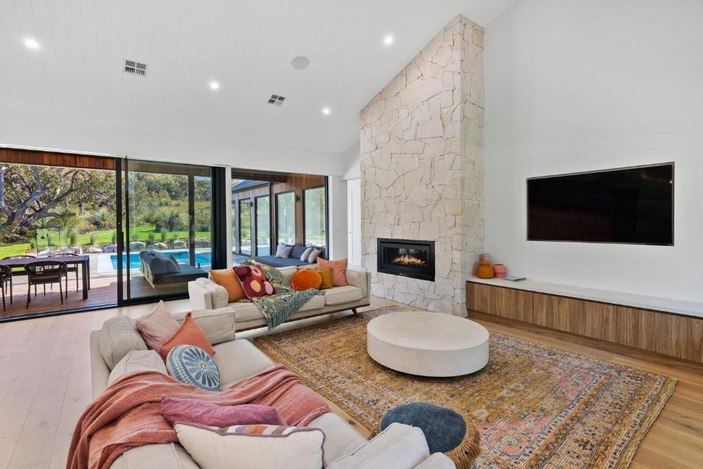 a living room with a couch and a fireplace at Moggs Creek Luxury Escape in Aireys Inlet