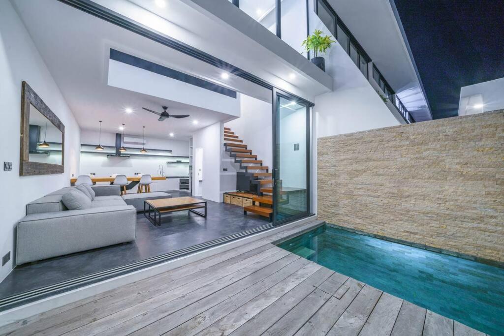 un salon avec une piscine et une maison dans l'établissement Loft Berawa 3 - Stunning 1-bdr luxury loft in Great Location !, à Canggu