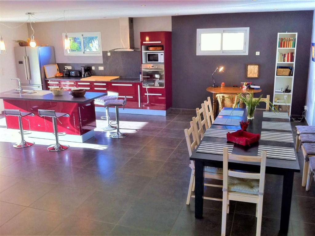 a kitchen with red cabinets and a table and chairs at Maison Vagnas, 4 pièces, 6 personnes - FR-1-382-176 in Vagnas