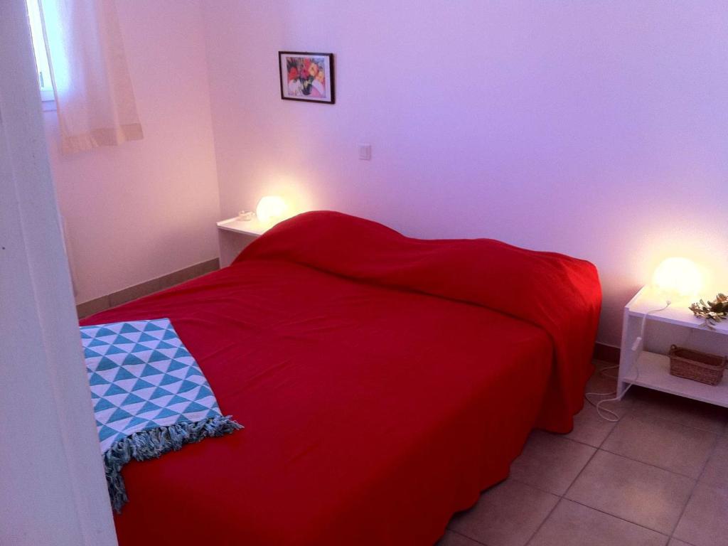 a red bed in a small room with two lights at Maison Vagnas, 4 pièces, 6 personnes - FR-1-382-176 in Vagnas