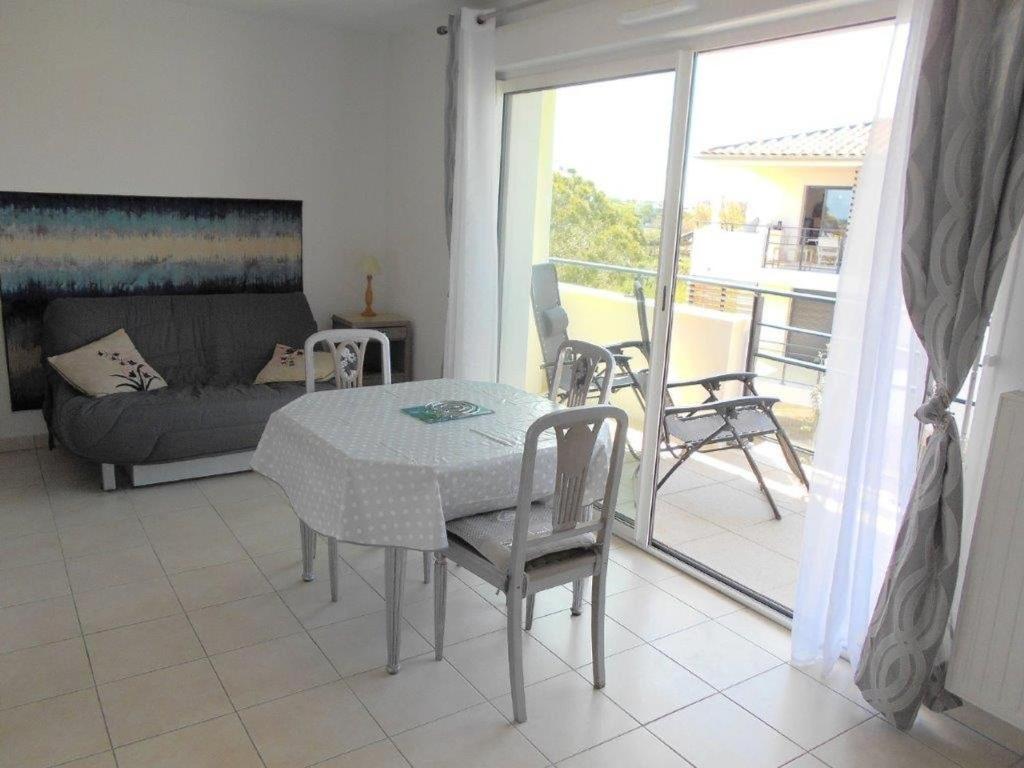 un salon avec une table, des chaises et un canapé dans l'établissement Appartement 2 pièces, terrasse, parking privé, proche plage et centre, Grau-du-Roi - FR-1-250-174, au Grau-du-Roi