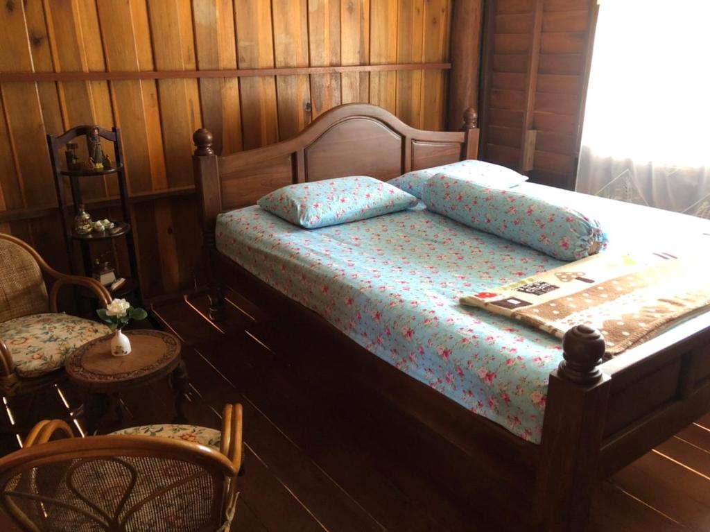 a bedroom with a bed with a wooden wall at Artist Homestay in Ko Yao Noi