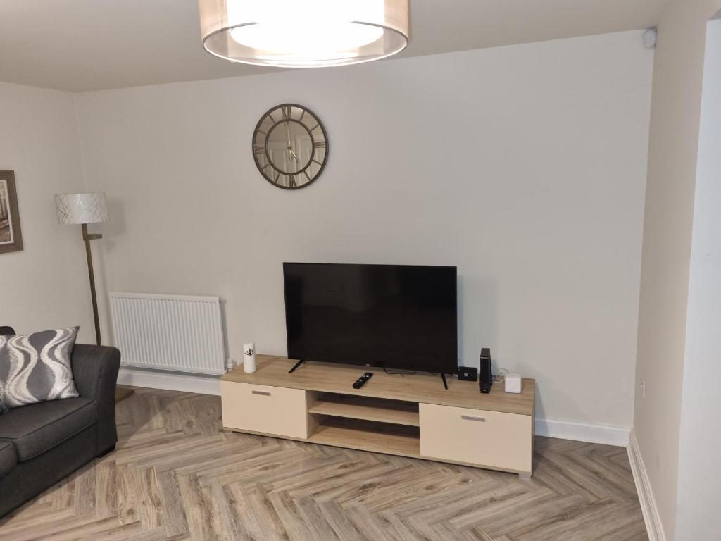 een woonkamer met een flatscreen-tv aan een witte muur bij 26 Lindhurst Way West in Mansfield