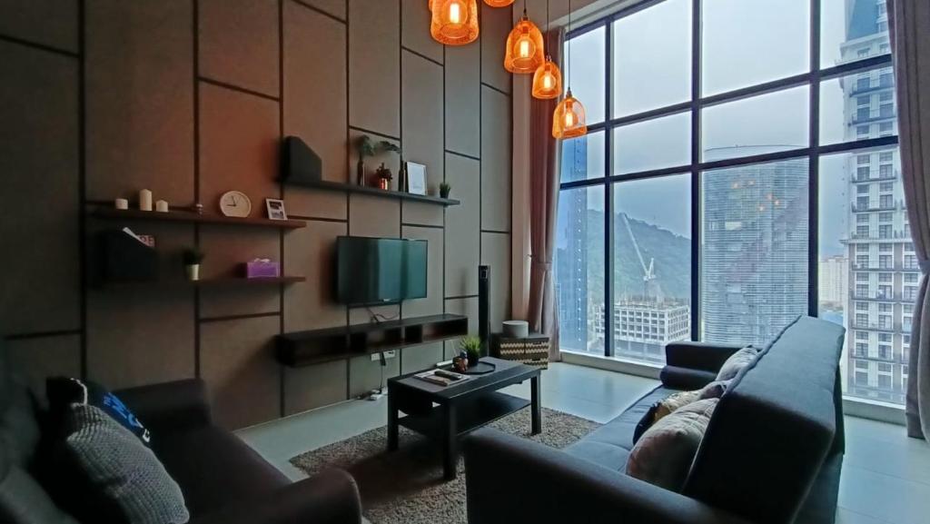 ein Wohnzimmer mit einem Sofa und einem großen Fenster in der Unterkunft Signature LOFT EMPIRE CITY WIFI NETFLIX in Petaling Jaya