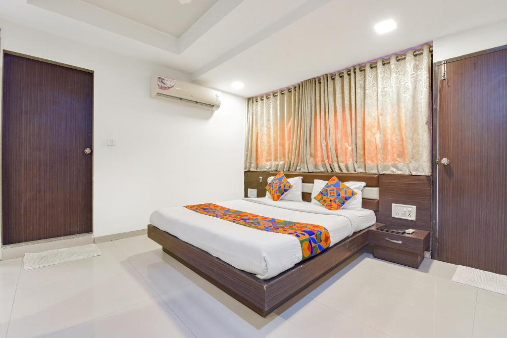 a bedroom with a bed and a window at FabHotel Skyland in Ahmedabad