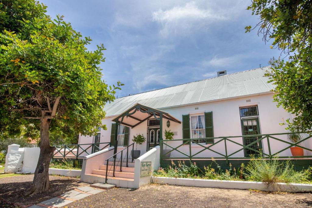 a building with a tree in front of it at Koo Karoo Guest Lodge and Self Catering in Montagu