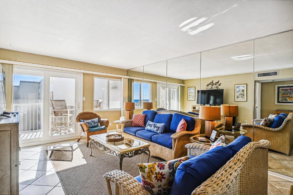 a living room with a blue couch and chairs at Holiday Surf & Racquet 614 Condo in Destin