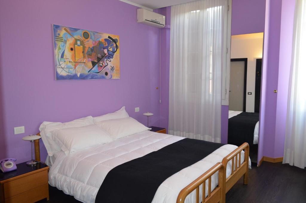 1 dormitorio con paredes moradas y 1 cama grande en Albergo Giardino, en Cernobbio