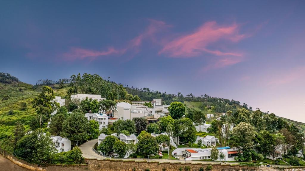 a group of white houses on a hill at Sterling Kodai Valley in Kodaikānāl