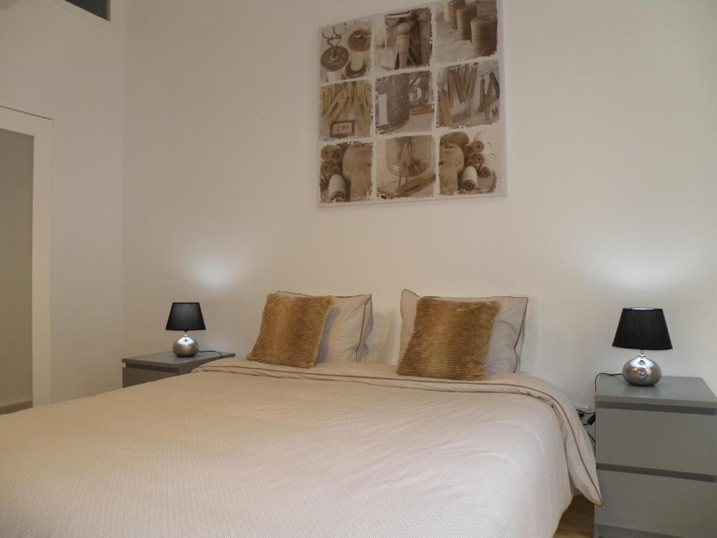 ein Schlafzimmer mit einem weißen Bett mit zwei Lampen in der Unterkunft Fashion Chiado - SSs Apartments in Lissabon