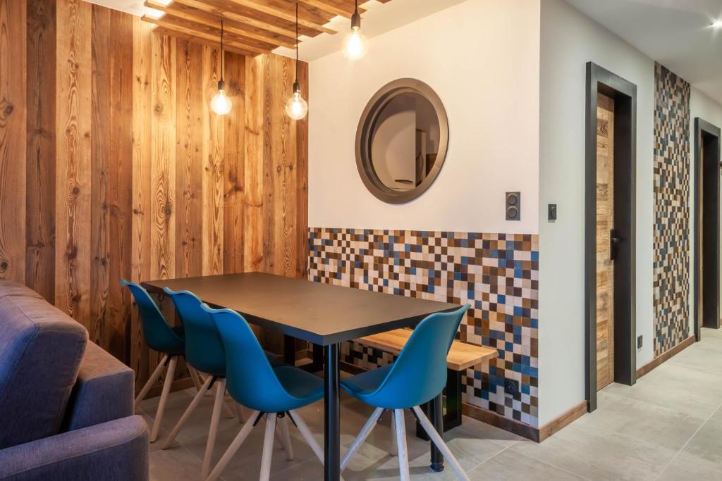 une salle à manger avec une table et des chaises bleues dans l'établissement Chevruls A9, à Morzine