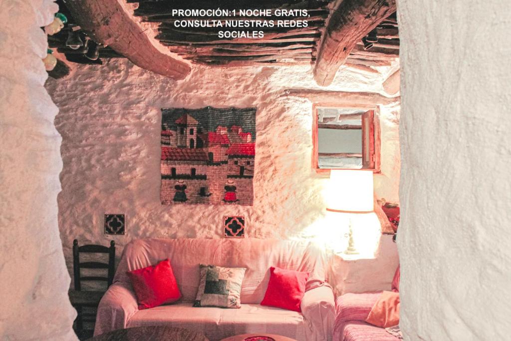 a living room with a couch in a stone wall at Apartamento El Refugio de Mecina in Mecina Fondales