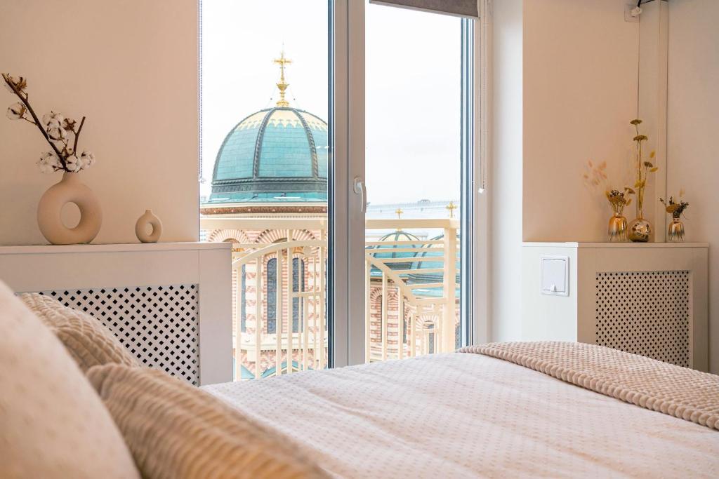a bedroom with a bed and a view of a building at Style and view Bucharest city center aparthotel in Bucharest