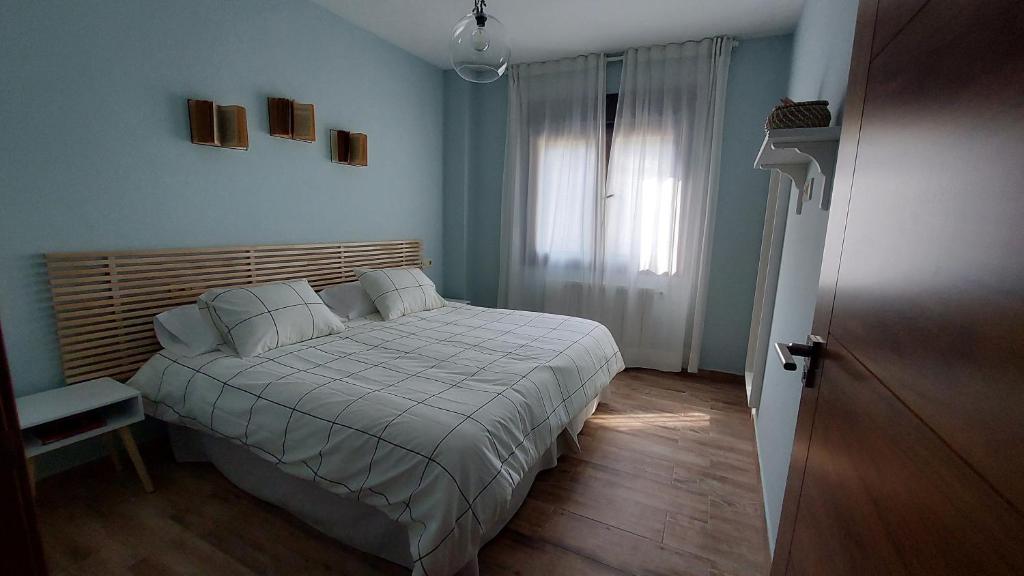 1 dormitorio con cama y ventana en Apartamento Las Campanitas, en Nuñomoral