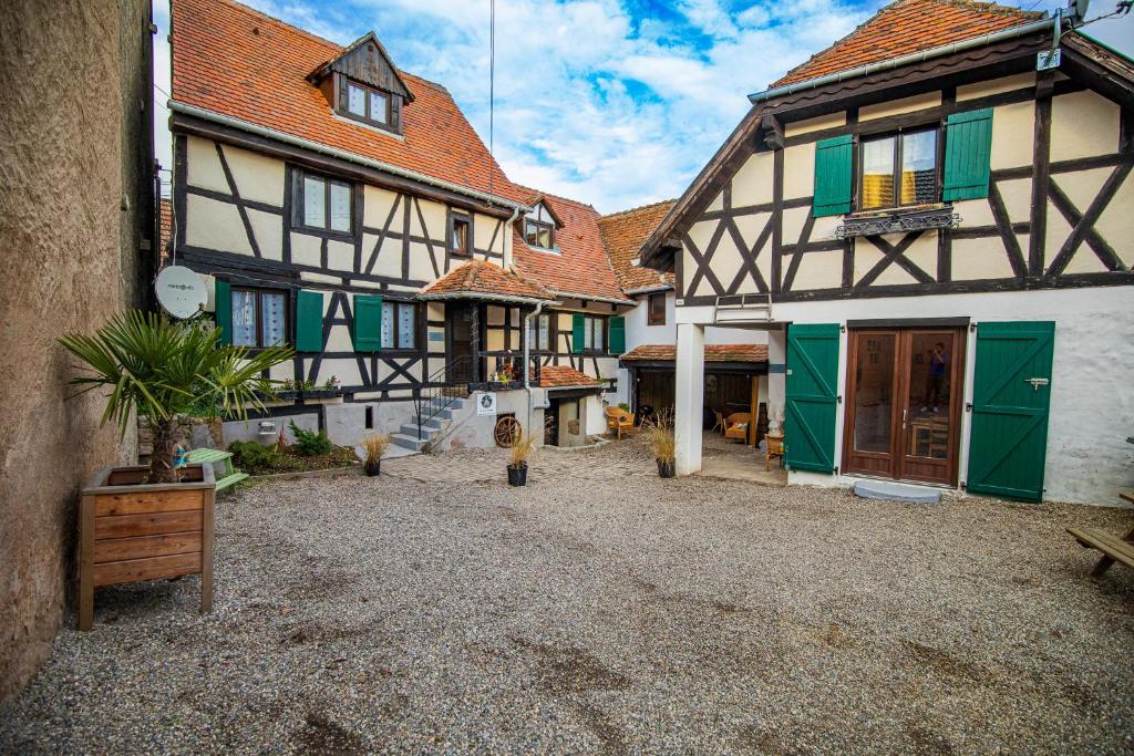 un grupo de edificios con puertas verdes y patio en Le Vieux Pressoir en Dieffenthal