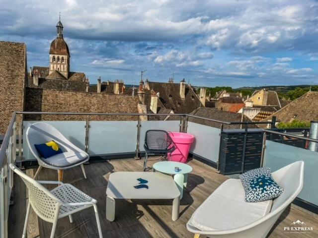 un balcón con sillas y mesas y un edificio en Les Terrasses de Notre Dame, en Beaune