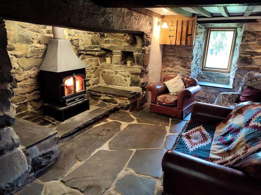 salon z kamiennym kominkiem i kanapą w obiekcie Y Cwtch - Panoramic mountain views within Snowdonia's National Park w mieście Dolgellau