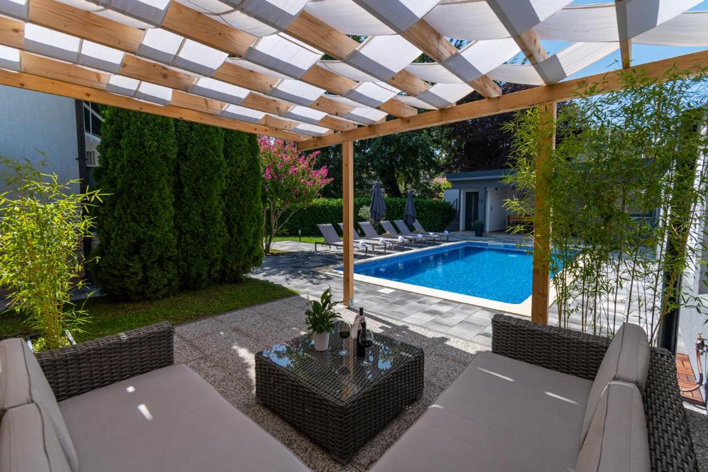a patio with a pergola and a swimming pool at The Oasis in Trilj