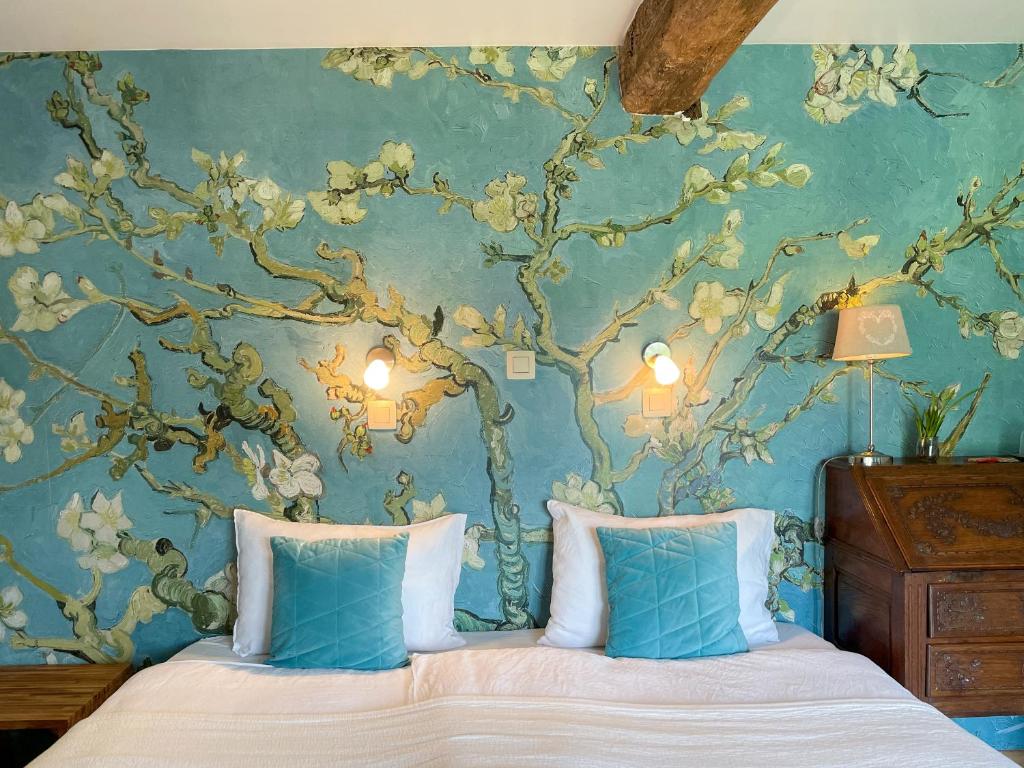 a bedroom with a tree mural on the wall at B&B De Paenhoeve in Eksel