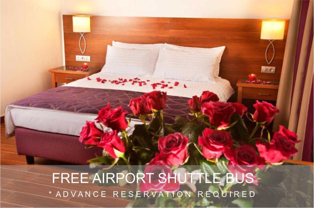 um quarto de hotel com uma cama com rosas vermelhas em Hotel Galileo em Praga