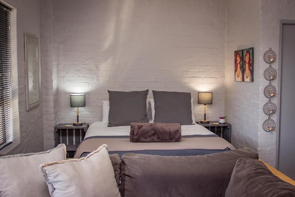 a bedroom with a large bed and a couch at Dragon Tree in Yzerfontein