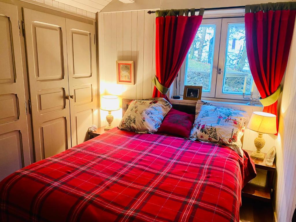 een rood bed in een kamer met een raam bij Cocon alpin, Situation top, Chalet Reine des neiges in Megève