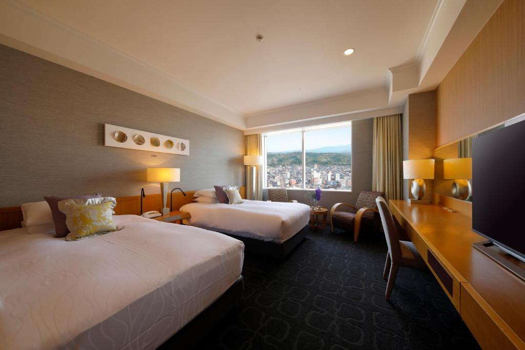 Hotel Nikko Kanazawa في كانازاوا: غرفة فندقية بسريرين وتلفزيون بشاشة مسطحة