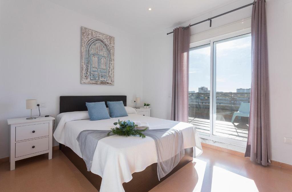 Dormitorio blanco con cama y ventana grande en Ático Terrazas Piscina Parking 3 Rooms 2 Baños, en Jerez de la Frontera