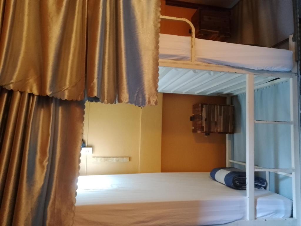 um quarto com 2 beliches e uma cortina em Funny Riverside Backpackers em Luang Prabang