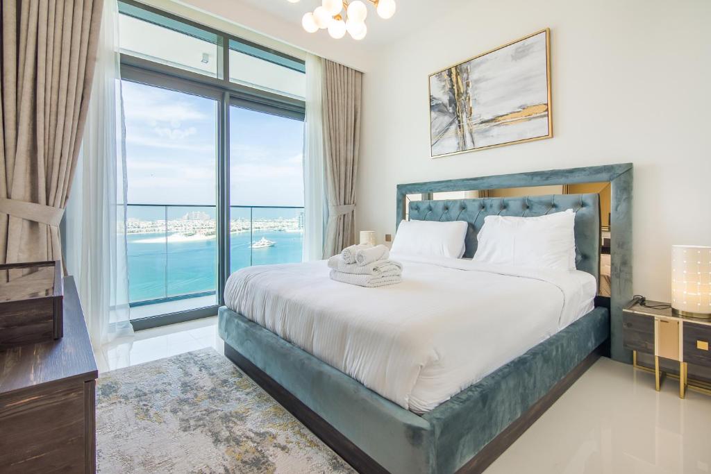 een slaapkamer met een groot bed en een groot raam bij 2BR Amazing Palm View - Private beach - Beach Vista T1 in Dubai