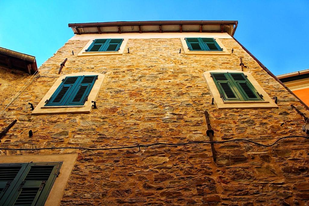 un edificio alto de ladrillo con tres ventanas. en Montegrazie Apartment, en Imperia