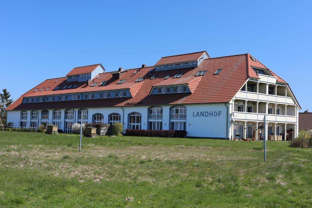 a large white building with a red roof at Der Landhof Möwe LH 103 in Stolpe