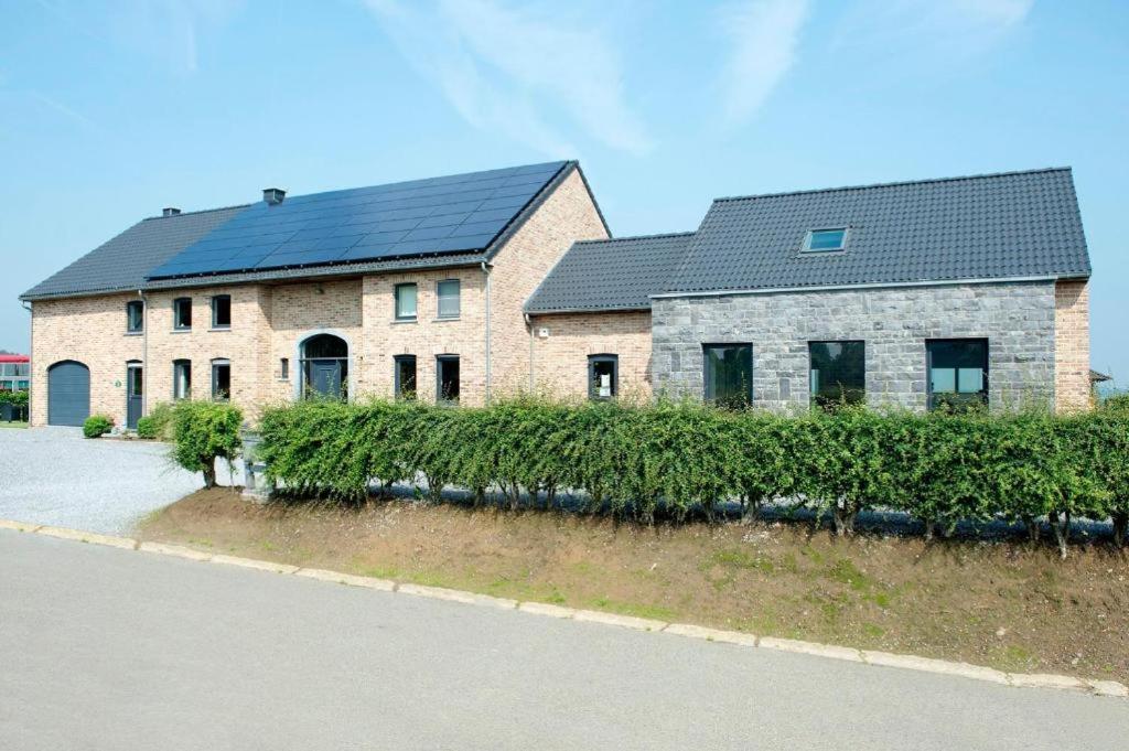 a large brick house with a black roof at Le Boca in Les Waleffes