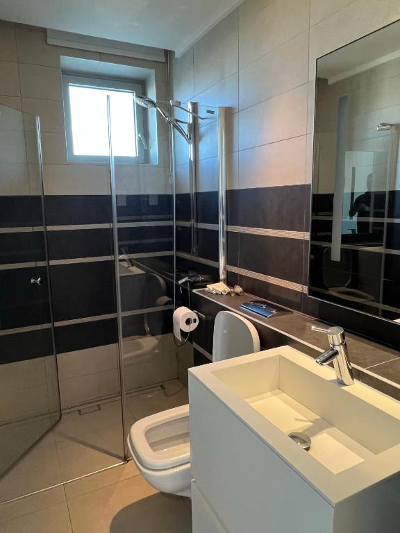 a bathroom with a sink and a toilet and a shower at Olympic Residence Deluxe Apartments in Limassol