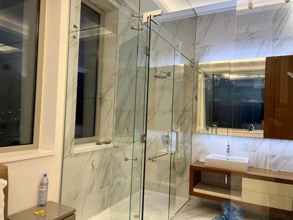 a bathroom with a glass shower with a sink at Olympic Residence Deluxe Apartments in Limassol