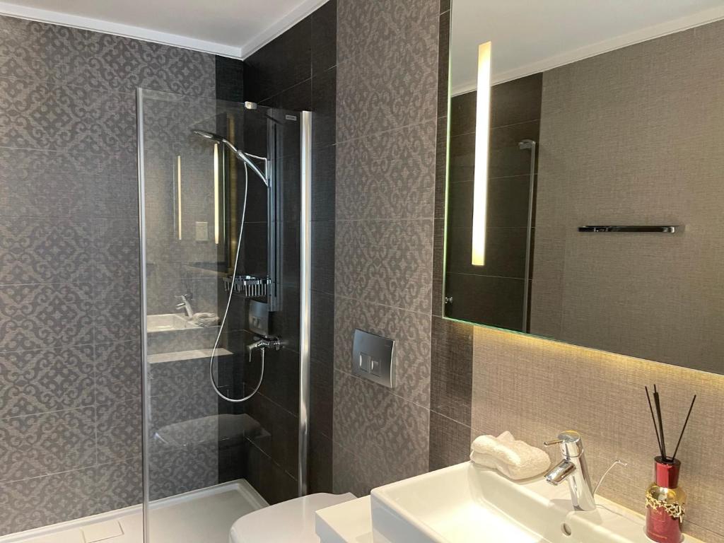 a bathroom with a shower and a sink and a mirror at Olympic Residence Deluxe Apartments in Limassol