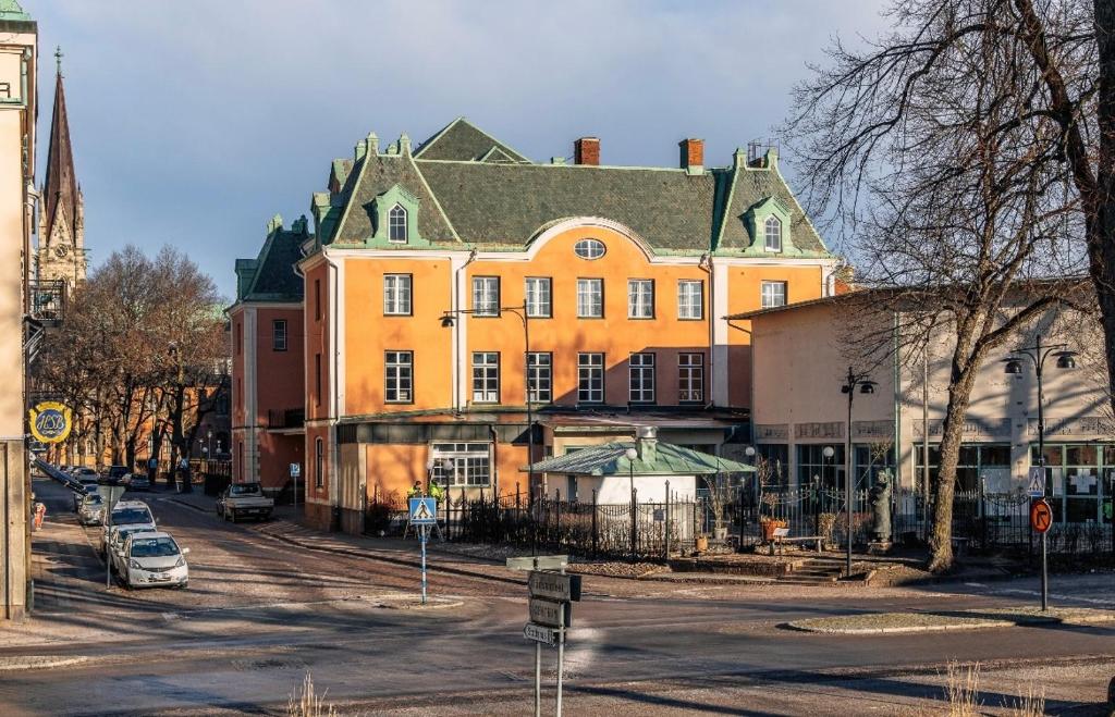 un gran edificio naranja con un coche aparcado delante de él en Skara Stadshotell, en Skara