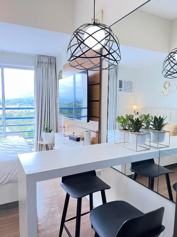 a kitchen and living room with a white table and chairs at Studio with mountain view, near Limketkai mall in Prime Cagayan de Oro in Cagayan de Oro