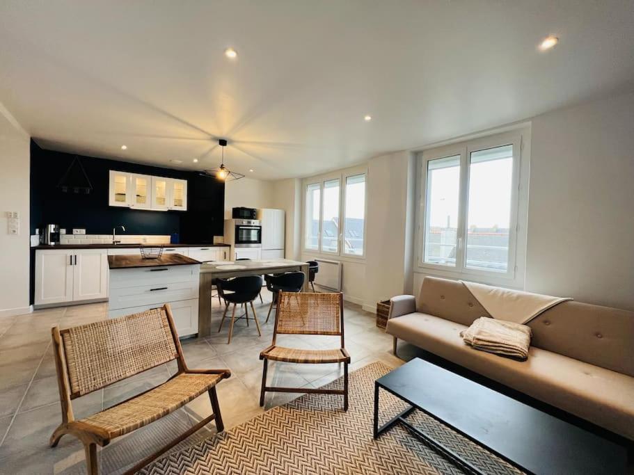 Il comprend un salon avec un canapé et des chaises ainsi qu'une cuisine. dans l'établissement Superbe appartement hyper centre, à Concarneau