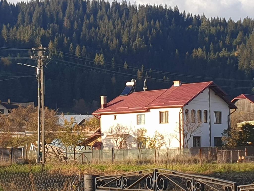瓦馬的住宿－Casa Rustic，山前有红色屋顶的白色房子