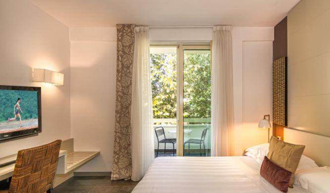 a bedroom with a bed and a view of a patio at Hotel Joseph in Marina di Pietrasanta