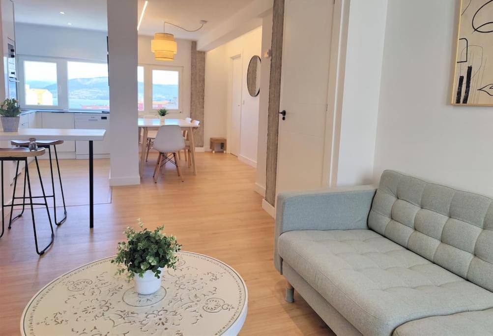 uma sala de estar com um sofá e uma mesa em Vistas, recién reformado, 2 dormitorios dobles. em Santander