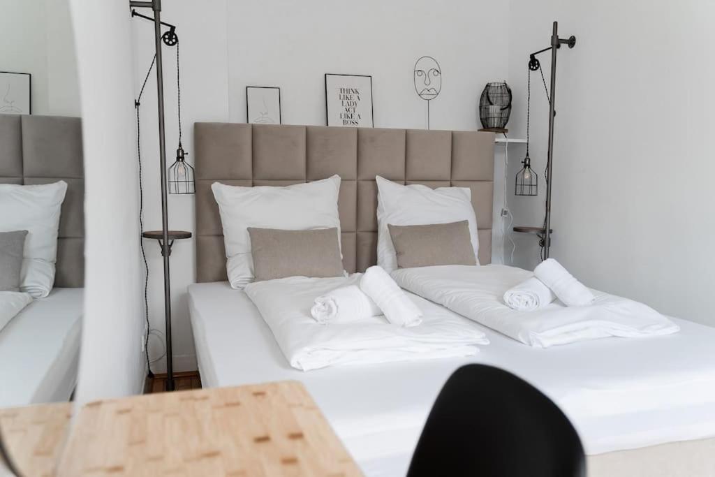 a large bed with white sheets and pillows at JUNIK Apartments - Deine Cityapartments in Duisburg in Duisburg