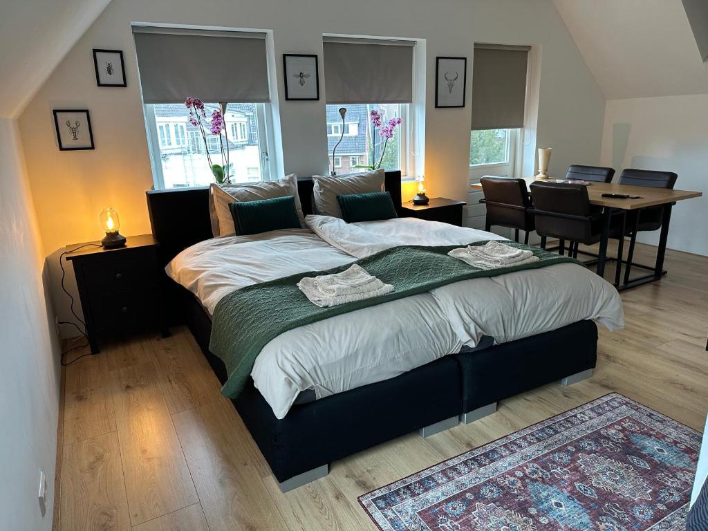 1 dormitorio con 1 cama grande con mesa y sillas en D10 Apartments, en Breda